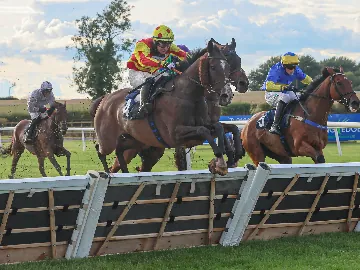 September Tuesday afternoon racing, sunny, horses jumping over fence
